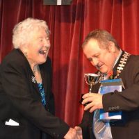 Stella Harvey being presented with her trophy by Town Mayor Brian Clemens